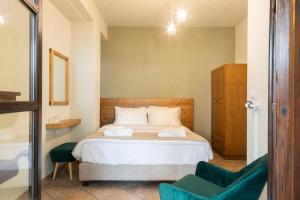 1 dormitorio con 1 cama y 1 silla verde en Hotel Katafigio, en Elati