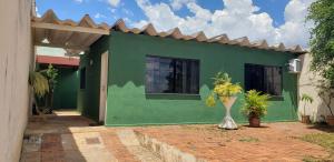 ein grünes Haus mit einer Vase davor in der Unterkunft Casa verde in Campo Grande
