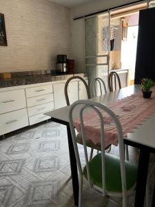 une cuisine avec une table, des chaises, une table et un comptoir dans l'établissement Hostel Diamante, à Diamantina