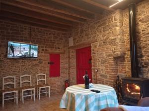 a room with a table and a tv on a brick wall at La Casita De Albino in Castillo de Bayuela