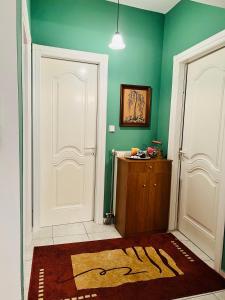 een kamer met twee witte deuren en groene muren bij Cozy place in Kozani