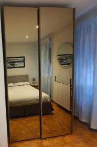 um espelho em frente a um quarto com uma cama em MARCO'S HOUSE em Sanremo