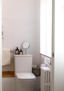 Baño blanco con aseo y espejo en Apartamentos Albacete, en Albacete