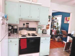 a kitchen with white cabinets and a stove top oven at 10 min Downtown-3 min Irvington in Indianapolis