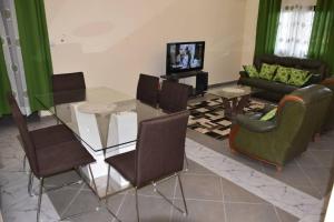 a living room with a glass table and chairs at RESIDENCE E.P in Emana