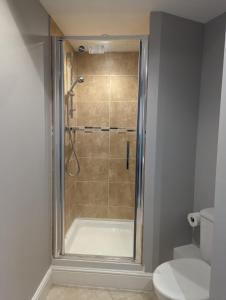 a bathroom with a shower and a toilet at Cosmo Suites in Bracknell