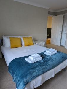 a bedroom with a bed with two towels on it at Cosmo Suites in Bracknell