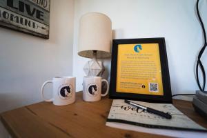 a desk with two coffee mugs and a computer on it at TinyHome at the Sanctuary in Lakeside