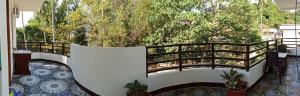 een balkon met een houten leuning en een boom bij Vali-Joe Travel Lodge in El Nido