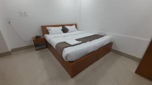 a bedroom with a large bed with white sheets at The PENTHOUSSE near ION Exam Centre & Airport in Guwahati