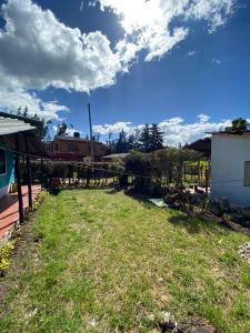 a yard with grass and a building and a sky at Casa Campestre Adela in Suesca