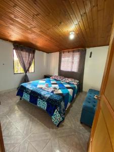 a bedroom with a bed and a wooden ceiling at Casa Campestre Adela in Suesca