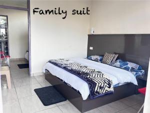 a bedroom with a bed with a family suite sign on the wall at FORTUNE HEIGHTS DALHOUSiE in Dalhousie