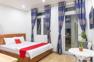 a bedroom with a bed and blue curtains at Rita Hotel Home- Airport Tân Sơn Nhất- Cạnh Bệnh Viện Tâm Anh & Gần Quân Khu 7 in Ho Chi Minh City