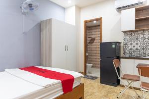 a small room with a bed and a refrigerator at Rita Hotel Home- Airport Tân Sơn Nhất- Cạnh Bệnh Viện Tâm Anh & Gần Quân Khu 7 in Ho Chi Minh City