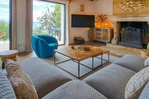 - un salon avec un canapé, une table et une cheminée dans l'établissement Villa Biloba - sea view and beach access 10 People, à Cricquebœuf