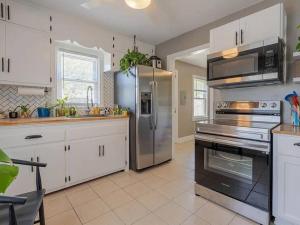 a kitchen with stainless steel appliances and white cabinets at Fenced-In Yard on the East Side in Evansville