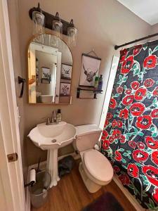 een badkamer met een wastafel, een toilet en een spiegel bij Fenced-In Yard on the East Side in Evansville