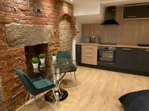 a kitchen with a glass table and a brick wall at Luxury Grand Studio Apartment @3 in Barnsley