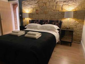 a bedroom with a large bed with towels on it at Luxury Grand Studio Apartment @3 in Barnsley