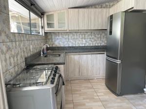 a kitchen with a refrigerator and a sink at Casa praia do santinho in Florianópolis