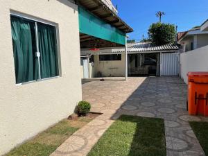 a house with a driveway next to a building at Casa praia do santinho in Florianópolis