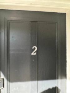 Una porta nera con il numero due sopra. di Villa Clara SUITE - Little Havana a Miami
