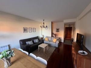a living room with a couch and a tv at Balcón del Cantábrico in Comillas
