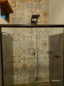 y baño con pared de azulejos y ducha. en Guest House Boki da Zezé, en Maraú