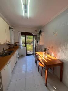 a kitchen with a wooden table and a sink at Balcón del Cantábrico in Comillas
