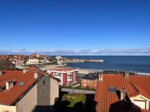 a view of a town with the ocean and buildings at Balcón del Cantábrico in Comillas