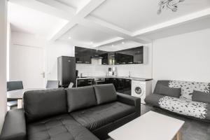 a living room with a couch and a kitchen at Appartement Montparnasse in Paris