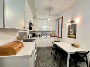 une cuisine avec des armoires blanches et une table avec des chaises dans l'établissement Cà De Sbiess, à Venise