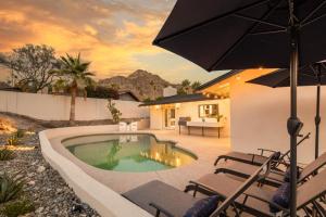 einen Pool mit Stühlen und einem Sonnenschirm in der Unterkunft Phoenix 22nd St in Phoenix