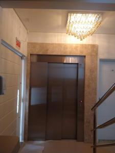 pasillo con ascensor y lámpara de araña en Apartamento 401 Palmas Beach, en Governador Celso Ramos