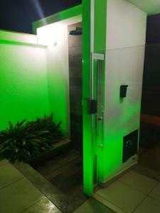 una luz verde en el baño con una planta en Apartamento 401 Palmas Beach, en Governador Celso Ramos