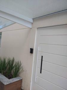 una puerta de garaje blanca con una planta al lado en Apartamento 401 Palmas Beach, en Governador Celso Ramos