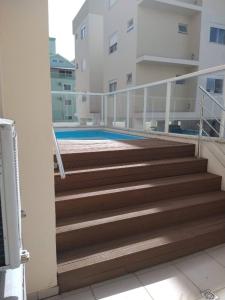 una escalera que conduce a una piscina en un edificio en Apartamento 401 Palmas Beach, en Governador Celso Ramos
