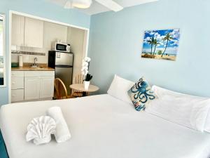 białe łóżko w pokoju z kuchnią w obiekcie St Maurice Beach Inn w mieście Hollywood