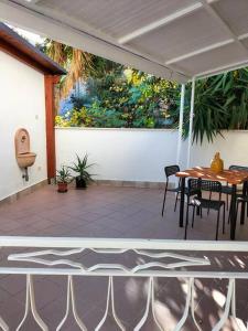 - une terrasse couverte avec une table et des chaises dans l'établissement SWEET HOME alternativo all'appartamento, à Pescara