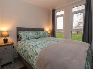 um quarto com uma cama e duas janelas em Holmside em Market Drayton