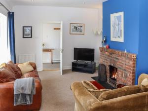 uma sala de estar com dois sofás e uma lareira em Seafield em Ballymoney Cross Roads