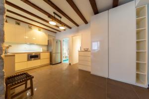 a large kitchen with white cabinets and a table at Apartman Škor in Komiža