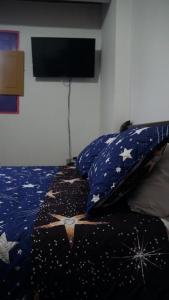 una camera da letto con letto a stelle e televisore di Hostal Palmas De Cocora a Salento Altre 37 foto