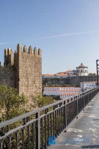 eine Brücke über eine Straße neben einem Schloss in der Unterkunft Porto Sé Classic Terrace Apartment in Porto