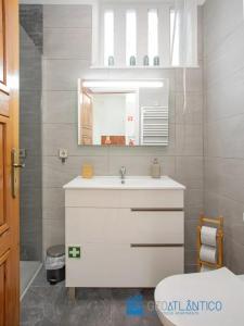 a bathroom with a white sink and a mirror at Porto Sé Classic Terrace Apartment in Porto
