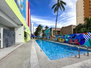 a pool at a hotel with chairs and palm trees at Park Inn By Radisson Mazatlán in Mazatlán