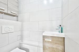 La salle de bains blanche est pourvue d'un lavabo et de toilettes. dans l'établissement Nice apartment, 15min from Paris, à Antony