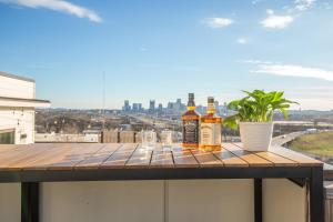 tres botellas de whisky sentadas en una mesa en un balcón en Jack Daniels House with Rooftop Golf, City views! 8min to Whiskey Row! Sleeps 10!, en Nashville