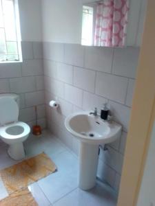 uma casa de banho com um lavatório e um WC em Anglerfish em Centurion